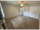 Cozy bedroom with plush carpeting, standard closets, neutral paint, and modern ceiling fan with light fixture at 1936 Se 37Th Court Cir, Ocala, FL 34471