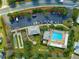 Overhead shot of community pool, shuffleboard, and parking area surrounded by mature trees and landscaping at 2630 Dunbar Ave, The Villages, FL 32162