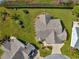 Aerial view of a single-story home with a well-manicured yard, brick driveway, and beautiful landscaping at 2630 Dunbar Ave, The Villages, FL 32162