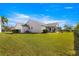 View of a spacious backyard showcasing a well-kept lawn and the rear exterior of the home with a screened lanai at 2630 Dunbar Ave, The Villages, FL 32162