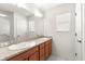 Bathroom featuring double sinks, granite counters, large mirror, and tiled floor at 2630 Dunbar Ave, The Villages, FL 32162