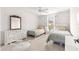 Shared bedroom with two twin beds, bright windows, ceiling fan, and a vintage-inspired mirror at 2630 Dunbar Ave, The Villages, FL 32162