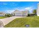 Traditional home with a brick driveway, a well-manicured front lawn, and an attached two-car garage at 2630 Dunbar Ave, The Villages, FL 32162