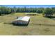 Aerial view of a metal building on a large property with a pond at 4248 Ne 175Th Street Rd, Citra, FL 32113