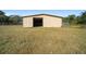 Tan metal barn exterior with open door at 4248 Ne 175Th Street Rd, Citra, FL 32113