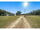 Driveway approaching two houses with sunny skies and mature trees at 4248 Ne 175Th Street Rd, Citra, FL 32113