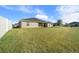 View of backyard from the side, showcasing a large grassy area and white fence at 5826 Sw 83Rd Ln, Ocala, FL 34476