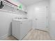 Bright laundry room with washer, dryer, and overhead shelving at 5826 Sw 83Rd Ln, Ocala, FL 34476