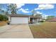 House exterior features a white garage door and landscaping at 6 Bahia Course Way, Ocala, FL 34472