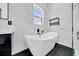 Modern bathroom with a luxurious soaking tub, black accents, and a marble tiled wall at 6877 Sw 131St Cir, Ocala, FL 34481