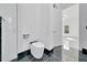 Modern bathroom with a sleek toilet, tiled walls, and open doorway to the primary bedroom at 6877 Sw 131St Cir, Ocala, FL 34481