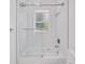 This bathroom features a modern shower-tub with glass door and a window at 6877 Sw 131St Cir, Ocala, FL 34481