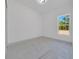 Bright bedroom featuring tile flooring and a large window providing tree views at 6877 Sw 131St Cir, Ocala, FL 34481