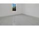 This bedroom is bright and spacious, with tile floors and a large window with tree views at 6877 Sw 131St Cir, Ocala, FL 34481