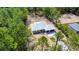 Stunning exterior view showcasing a white home with a metal roof surrounded by lush trees at 6877 Sw 131St Cir, Ocala, FL 34481