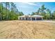 A contemporary single Gathering home features minimal landscaping, an attached garage, and long driveway at 6877 Sw 131St Cir, Ocala, FL 34481