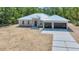 Stunning new construction home with metal roof, modern wood front door and concrete driveway at 6877 Sw 131St Cir, Ocala, FL 34481