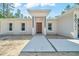Close-up of a modern home entrance featuring a wood door, white columns and concrete walkway at 6877 Sw 131St Cir, Ocala, FL 34481
