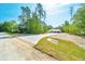 View of home's front exterior with new driveway and expansive lot at 6877 Sw 131St Cir, Ocala, FL 34481