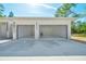 Exterior of a modern two-car garage with insulated doors and ample parking space at 6877 Sw 131St Cir, Ocala, FL 34481