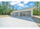 Modern home featuring a spacious two-car garage with contemporary doors and ample driveway space at 6877 Sw 131St Cir, Ocala, FL 34481