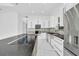 Bright kitchen featuring custom cabinetry, a stainless steel farmhouse sink, and granite countertops with a modern cooktop at 6877 Sw 131St Cir, Ocala, FL 34481