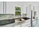 Close-up of a modern kitchen with a farmhouse sink, stainless steel appliances, and beautiful cabinetry at 6877 Sw 131St Cir, Ocala, FL 34481