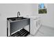 Functional laundry area with a modern sink and washer/dryer setup, bathed in natural light at 6877 Sw 131St Cir, Ocala, FL 34481