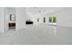 Bright open floor plan with modern tile flooring, leading to a kitchen and outdoor access through elegant French doors at 6877 Sw 131St Cir, Ocala, FL 34481