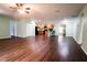 Spacious living room featuring hard wood floors, ceiling fan, and a partial view of the kitchen at 70 Se 81St Pl, Ocala, FL 34480