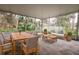Relaxing screened porch with wooden furniture and leafy views at 70 Se 81St Pl, Ocala, FL 34480