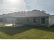Home's rear elevation, showcasing a covered patio and grassy yard at 7661 Sw 180Th Cir, Dunnellon, FL 34432