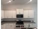 Modern kitchen featuring white cabinetry, granite countertops, and stainless steel appliances at 7661 Sw 180Th Cir, Dunnellon, FL 34432
