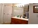 Bathroom vanity with wood cabinets and large mirror at 7990 Midway Drive Ter # M102, Ocala, FL 34472