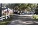 Road view of community with white fences and mature trees at 7990 Midway Drive Ter # M102, Ocala, FL 34472