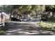 Road view of community with white fences and mature trees at 7990 Midway Drive Ter # M102, Ocala, FL 34472