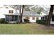 Back exterior showcasing screened porch and green lawn at 7990 Midway Drive Ter # M102, Ocala, FL 34472