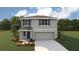 Two-story house with gray siding, two-car garage, and landscaping at 8699 Sw 44Th Ter, Ocala, FL 34476