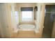 Bright bathroom featuring an elevated whirlpool tub with tile surround and decorative columns at 9340 Sw 9Th Ter, Ocala, FL 34476