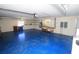 Large garage features a blue floor, storage racks, work bench and laundry area at 9340 Sw 9Th Ter, Ocala, FL 34476