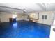 Spacious garage with blue epoxy floor, shelving, and workbench at 9340 Sw 9Th Ter, Ocala, FL 34476