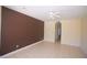 Living room with light tile floor, accent wall, arched doorway, and neutral paint color at 9340 Sw 9Th Ter, Ocala, FL 34476
