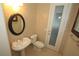 Powder room featuring a pedestal sink, elongated toilet, neutral tile, and a door with obscured glass at 9340 Sw 9Th Ter, Ocala, FL 34476