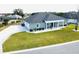 Gray house with a three-car garage and rocking chairs on the porch at 9645 Se 61St Ter, Belleview, FL 34420