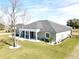 Single-story home with gray siding, gray roof, and a screened porch at 9645 Se 61St Ter, Belleview, FL 34420