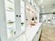 White kitchen cabinets with glass-front display cabinets and a stone backsplash at 9645 Se 61St Ter, Belleview, FL 34420