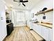 Bright laundry room with white cabinets, wood countertops, and shelving at 9645 Se 61St Ter, Belleview, FL 34420