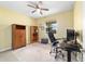 Bright home office features built-in shelving, desk, and ceiling fan at 9958 Sw 97Th Ln, Ocala, FL 34481
