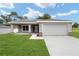 Newly constructed one-story home with gray exterior, stone accents, and a two-car garage at 10120 Se 130Th St, Belleview, FL 34420