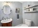 Small half bathroom with pedestal sink and floating shelves at 10455 Se 143Rd St, Summerfield, FL 34491